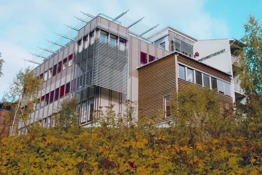 En bygning med trær foran seg